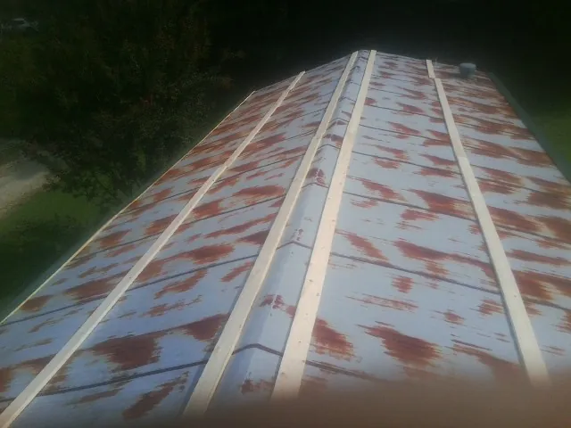 Rusted metal roof panels with new wood purlins before replacement — Storm Damage Roof Repair in Davidsville by Roofing Brothers