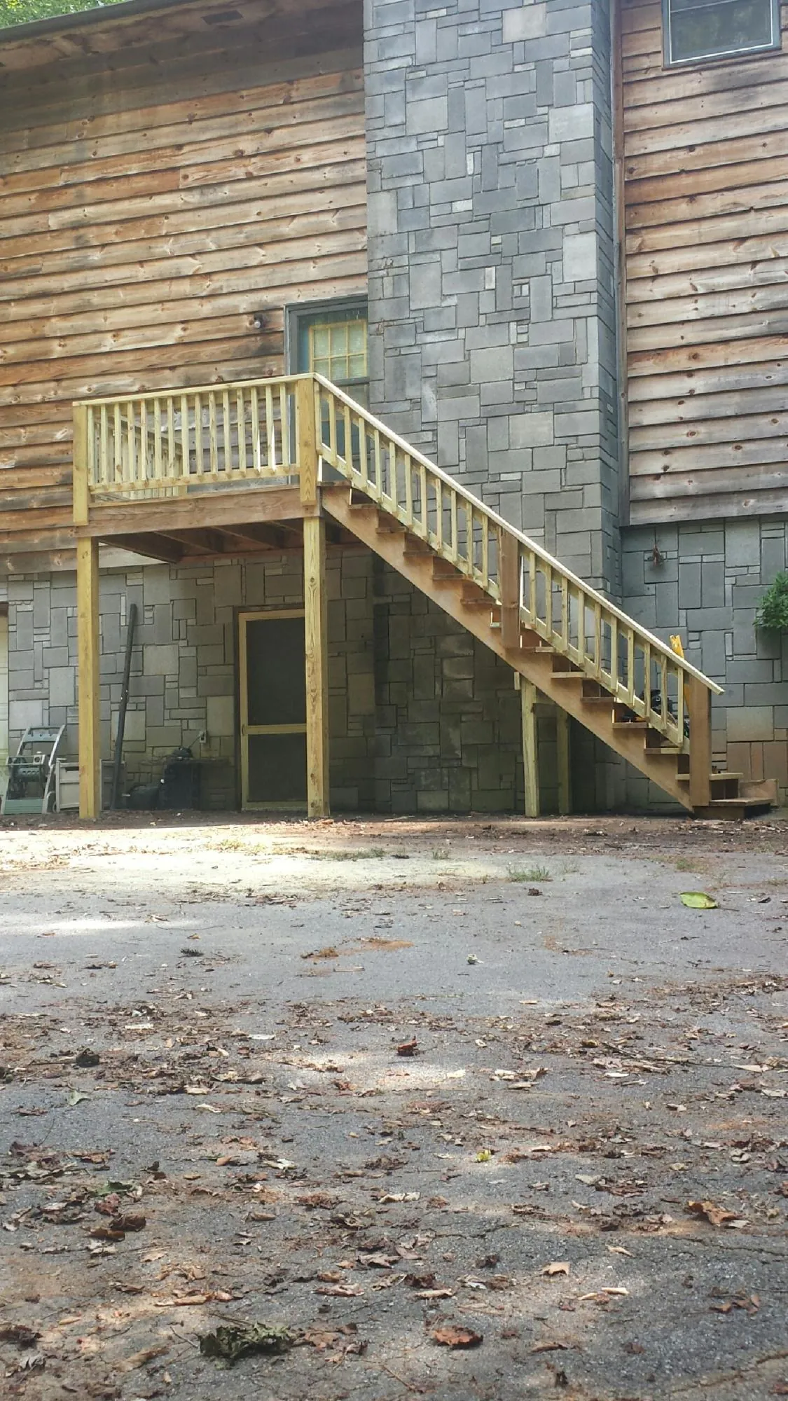 New pressure treated deck and stair landing on a log home in Davidsville