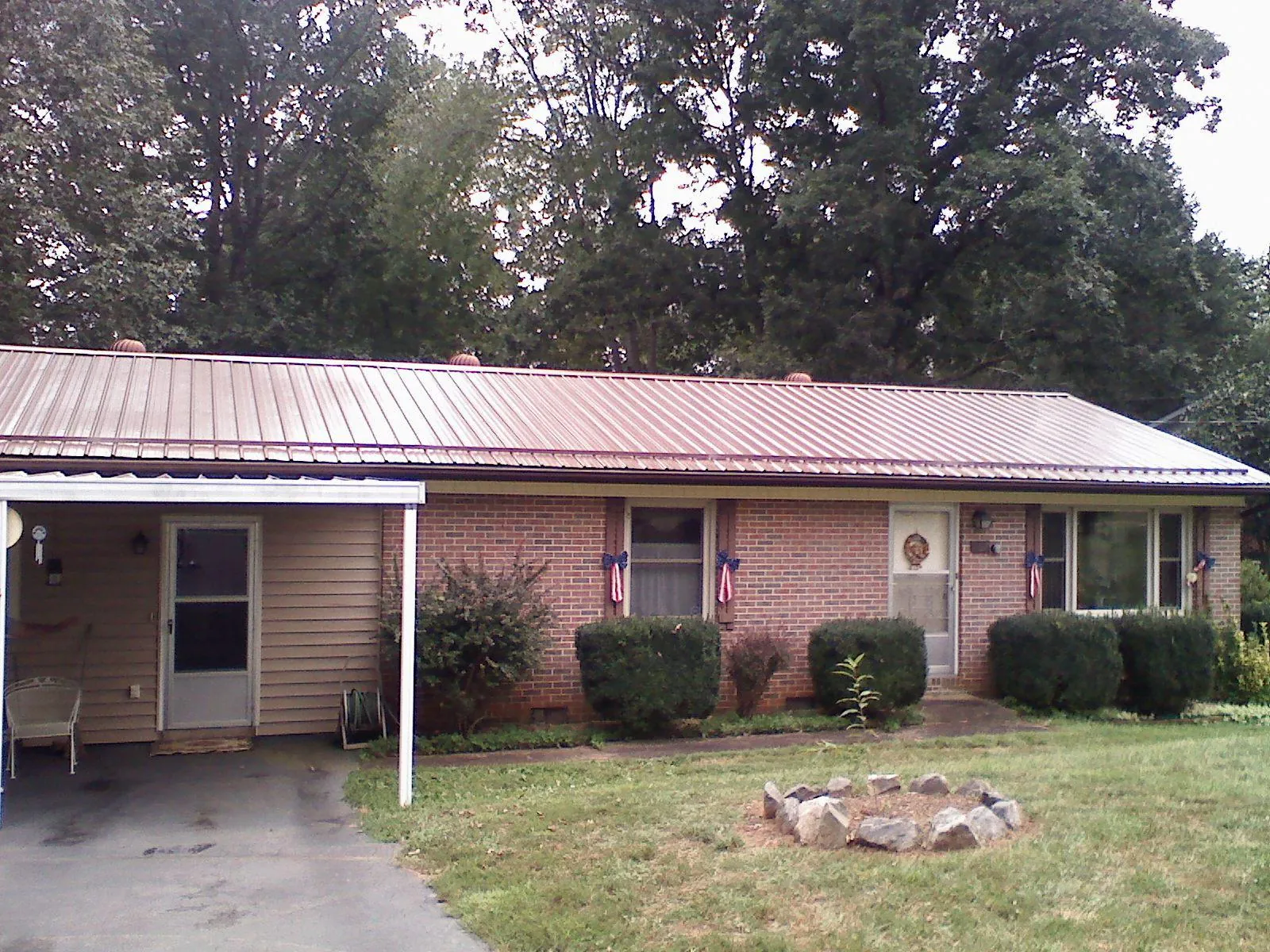 Bronze metal roof and carport on a brick ranch home — Roof Repair work by our crew in Davidsville